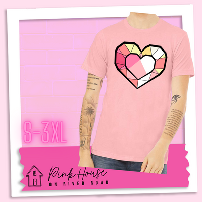 Pink graphic tee. the graphic is of a geometric heart, it has black outlines to make it look like a gem with different shades of pinks, yellows, and white.